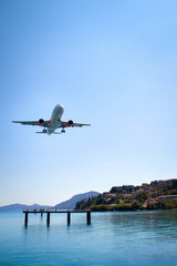 Fototapeta na wymiar an airplane approaching Corfu town, close to the sea, Landing approach to Kerkyra Airport, Corfu Town Greece