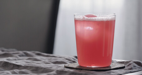 organic pink drink into tumbler glass on linen cloth with copy space