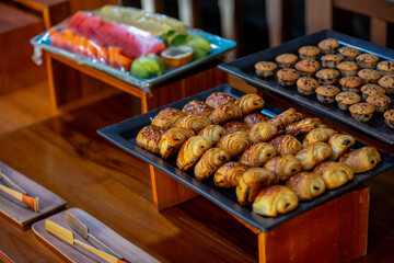 Assortment baked pastry in the buffet. Various different types of sweet cakes, cookies, candies, fruits and other desserts on display. Catering for birthday, wedding, Sunday brunch or other event
