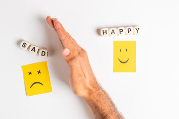 dice form word Happy and sad, smiley and sad face on yellow sticky note, choosing happy over sad,...