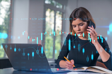 Pensive attractive beautiful businesswoman in working on laptop, talking phone, office workplace in background. Forex graph and charts hologram icons. Concept of market trading and research.