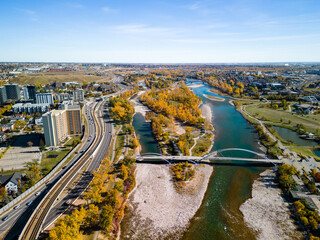 Fototapeta na wymiar St. Patrick's Island Park and Bow River and Memorial Drive aerial view in autumn season. Fall foliage in City of Calgary, Alberta, Canada. George C. King Bridge.