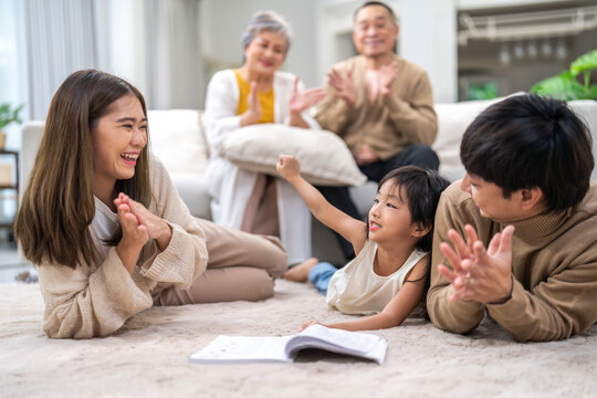 Portrait happy love asian family father and mother teach little daughter asian girl learn and study.Mom and asian young girl reading book making lessons in homeschool at home.Education