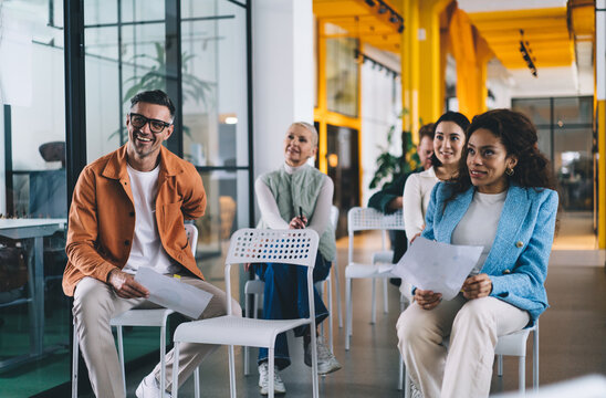 Smiling colleagues listening seminar in conference room