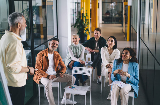 Happy diverse coworkers having discussion while talking about work in office
