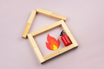 A box of matches placed next to a toy red fire extinguisher against a light background.