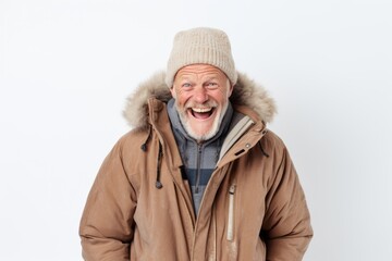 Fototapeta premium Portrait of a joyful man in his 60s wearing a warm parka against a white background. AI Generation