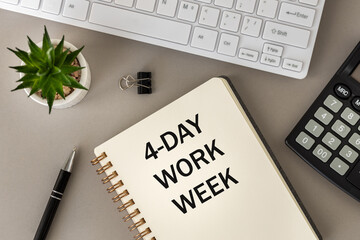 4 day work week symbol, conceptual words "4 day work week" in notebook on desk at work. Beautiful gray background. Copy space. Business concept and 4-day work week.