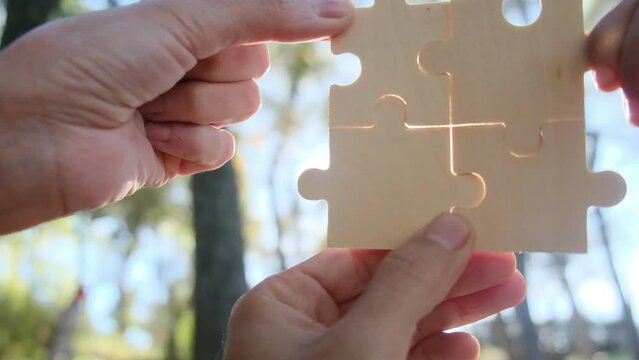 Embracing teamwork's innovative and creatively developmental approach, fostering efficient solutions through interdisciplinary collaboration. Diverse hands, various ages, collaborating on a puzzle.

