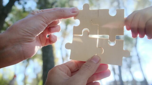 Hands of individuals across various age groups coming together to piece a puzzle, embodying the essence of teamwork, cooperation, and effective problem-solving. Witness the power of collaboration.