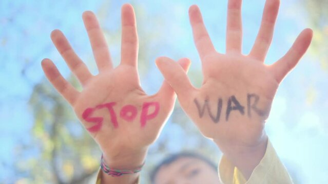 In the gentle grasp of a child's hands unfolds a poignant plea: 'Stop war.' This symbolic gesture embodies anti-war sentiments, pacifism, opposition to arms sales, and the commitment to violence