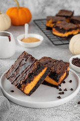 Chocolate brownies with spicy pumpkin cheesecake. Halloween or Thanksgiving dessert. Copy space.
