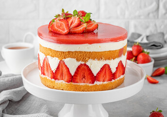 Fraisier mousse cake. Strawberry cake with sponge cake, mousse and jelly on a gray concrete background. Summer dessert. Selective focus. Copy space