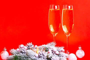 Champagne glasses and christmas decorations on red background. New year atmosphere.