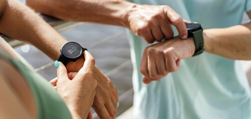 Looks at the sports watch and workout results in the app. Sports accessories on the hands of...