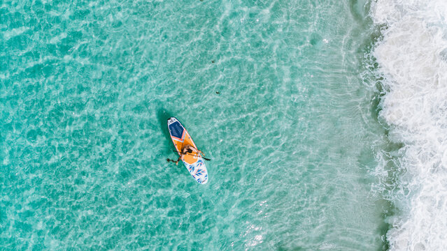 Overhead Drone View Of A Person On His Stand Up Paddle Board In The Sea With Green Water On The Beach With The Whitest Sand In The World In Jervis Bay, Australia On A Daylight Morning On Vacation