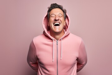 Obraz premium Portrait of a joyful man in his 50s wearing a zip-up fleece hoodie against a pastel gray background. AI Generation