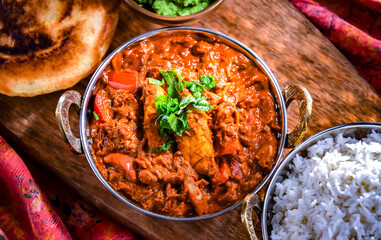 Butter chicken with rice and naan bread served in karahi pots