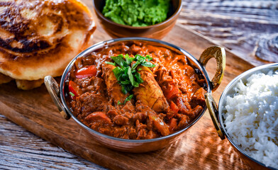 Butter chicken with rice and naan bread served in karahi pots