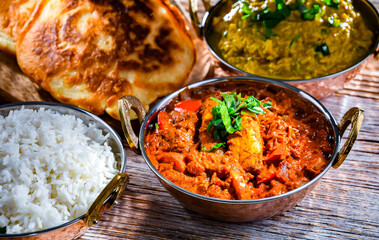 Butter chicken with rice and naan bread served in karahi pots