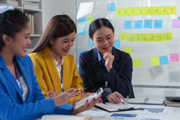 Asian business colleagues present and discuss investment project work and planning strategies. Budget calculation Income from documents reporting the company's business growth.