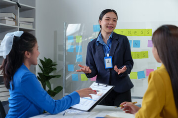 Group of colleagues, Asian businesswomen presenting and explaining investment project reports and planning strategies Budget calculation, business growth report on company laptop.