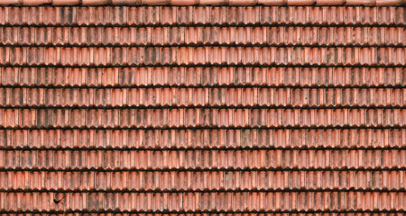 Close up of red terracotta roof shingles with some mildew. Background texture of old roofing material © mehaniq41