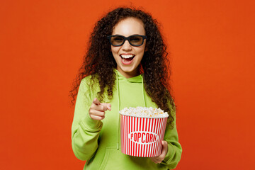 Young woman of African American ethnicity in green hoody casual clothes 3d glasses watch movie film...
