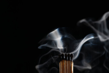 Ignition of matches with smoke, isolated on black background. Match just after burning.