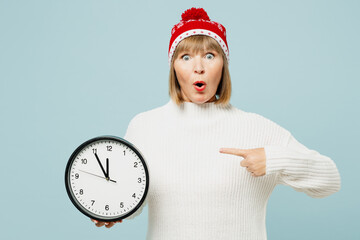 Merry shocked elderly woman 50s years old wear sweater red hat posing hold in hands point index...