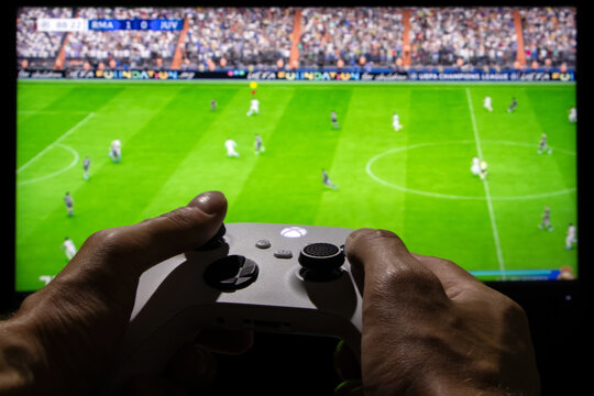 Dnipro, Ukraine, 28 september 2023: Man playing EA FC 24 with Xbox controller on TV screen