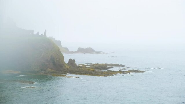 Misty shot of Tantallon Castle and the Bass Rock, a ruined mid-14th-century fortress located in North Berwick, Scotland, UK