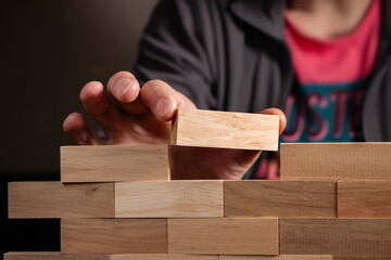 Man holding blocks wood game jenga Build wall.
