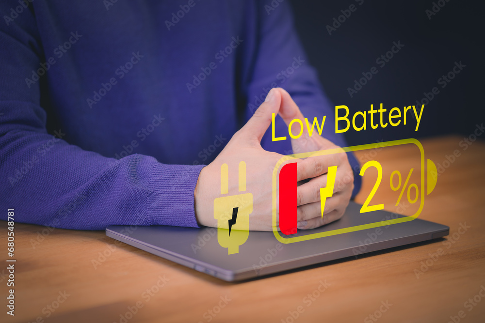 Poster Laptop out of battery. Concept of Technology and daily life. Man is angry and frustrated when he learns that his laptop computer's battery is dead and did not bring the charger adapter.