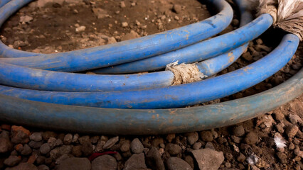 Blue hose reel on the ground. Used to water flowers and plants