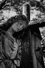 statue of an angel with a cross in the cemetery