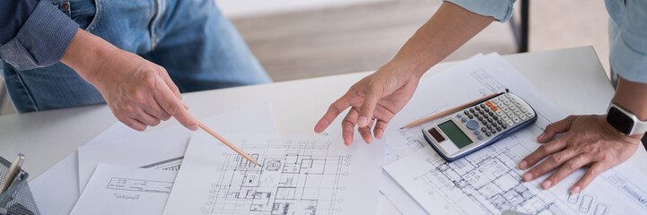 Two engineer architect pointing on blueprint of sketching interior architectural building to...