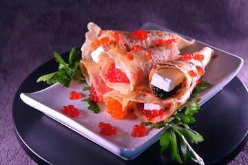 Pancakes with red caviar , black caviar with Feta cheese decorated with herbs. Delicious Healthy Food