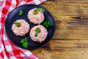 Appetizer of crab-cheese balls made in a shape of Christmas baubles on wooden table. Top view