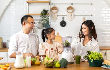 Fotobehang Portrait of enjoy happy love asian family father and mother with little asian girl daughter child having fun help cooking food healthy eat together with fresh vegetable salad ingredient in kitchen © Art_Photo