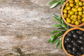 Green and black olives on a white wooden background. Various types of olives in bowls and olive oil...