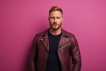 Fototapeta premium Portrait of a content man in his 30s sporting a classic leather jacket against a solid pastel color wall. AI Generation