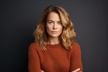Fototapeta premium Portrait of a content woman in her 30s dressed in a warm wool sweater against a blank studio backdrop. AI Generation