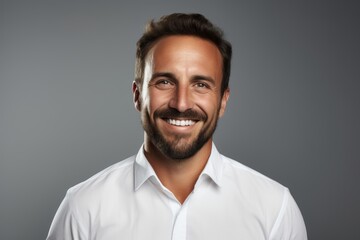 Fototapeta premium Portrait of a smiling man in his 40s wearing a classic white shirt against a plain white digital canvas. AI Generation