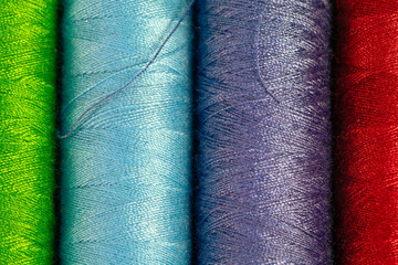 Spools of colored threads. Spools of green, blue, purple and red thread for sewing