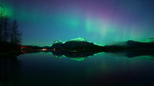 Shy aurora dancing above crystal clear waters in lake Vatnvatnet in Bod&oslash; in October.
