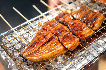 Charcoal grilled eel or unagi sticks which are selling at the fish market, on of the most famous...