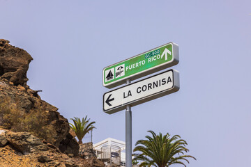 Close-up of signs indicating direction to Puerto Rico Beach and highway towards La Cornisa on...