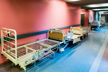 Patient beds being stored in the corridor of a hospital.