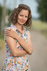 Fototapeta premium Beautiful young girl in a summer dress outdoors in the village.